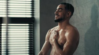 Hint İspanyol asıllı 30 'lu yaşlarda seksi Latin erkek sporcu model losyonlu duş jeli şampuan şişesiyle yıkanan çıplak, ıslak, kaslı, köpüklü, sıvı sabunlu suyla güçlü vücut rahatlatan adam.