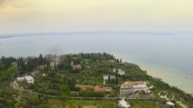 Garda Gölü 'ndeki lüks tatil köyünün havadan görünüşü İtalya' nın tarihi Sirmione adası harika göl kenti lüks villalar Avrupa arkeoloji sahasında gezintiler için turistik bir yer ünlü şatoyu harap ediyor.