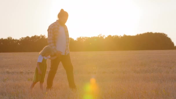 야외에서 일출을 실루엣 마리의 실루엣 아버지 아버지는 밀밭을 공원에서 있습니다 — 비디오