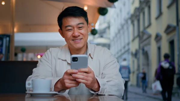 Gülümseyen Asyalı Turist Elinde Cep Telefonu Ile Oturmuş Internetten Bilet — Stok fotoğraf