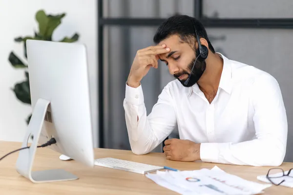 Empresario, gerente o consultor indio descorazonado por el exceso de trabajo, sentado en un escritorio de la oficina, con los ojos cerrados, que necesita descansar en una situación estresante, tiene dolor de cabeza, migraña — Foto de Stock