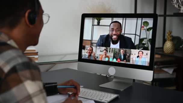 Fernstudium, Online-Bildung. Blick über die Schulter eines Mannes, Computerbildschirm mit multirassischen Menschen, Lehrerin hält Online-Vorlesung für Schüler per Videoanruf, virtuelles Besprechungskonzept — Stockvideo