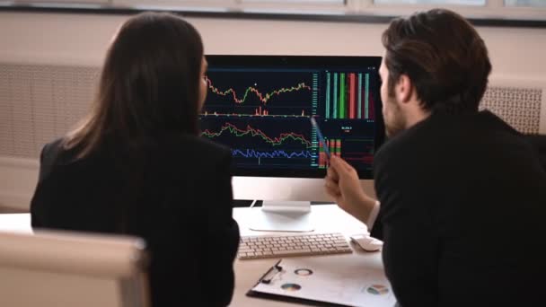 Два успешных брокера инвестор, мужчина и женщина, используя компьютер для анализа финансового рынка криптовалют, инвестирует в электронную валюту, анализирует финансовые данные, стратегию планирования, в офис — стоковое видео