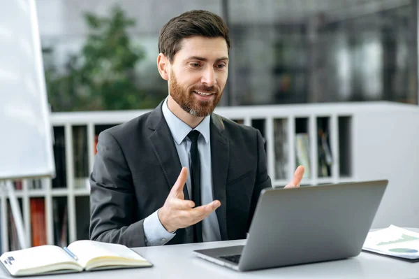 Distant telecommunication, online business meeting. Successful confident caucasian businessman, mentor, company owner, holding online conference with employees via video call, sits in modern office