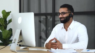 Uzaktan iletişim, sanal online toplantı. Başarılı bir Hintli adam, akıl hocası, şirket sahibi, çalışanlarla çevrimiçi konferans düzenleyen, ofiste bir masada oturan