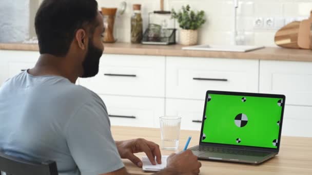 Зеленый экран ноутбука. Индийский мужчина исполнительный, фрилансер, имеющие онлайн виртуальную встречу через видео-конференцию с успешными многорасовыми коллегами, используя ноутбук, планируя маркетинговую стратегию и идеи — стоковое видео