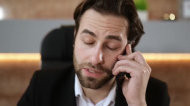 Busy successful caucasian intelligent man, company ceo, sales manager, IT specialist, busy with work in modern office, having phone conversation with client, looking through documents, using a laptop