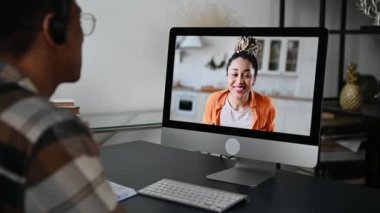 Bayan bir iş arkadaşı, kız arkadaşı ya da arkadaşıyla uzaktan iletişim. Latin bir adam video konferansında bilgisayar ve uygulama kullanarak Afro-Amerikalı bir kızla konuşuyor, farklı konularda sohbet ediyor.