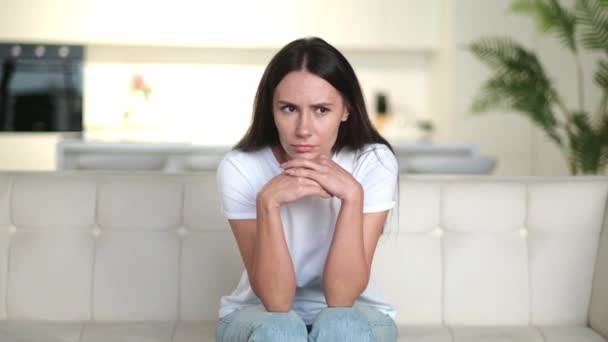 Enttäuschte unglückliche kaukasische junge Frau, die auf dem Sofa im Wohnzimmer sitzt, sie hat persönliche Probleme, Versagen bei der Arbeit, Depression, schlechte Laune, trauriges Mädchen ist einsam zu Hause — Stockvideo