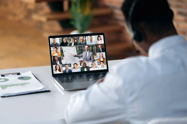 Zakelijke briefing. Zwarte man kijkt naar laptop scherm, praten op video gesprek met multinationale business group, houdt conferentie, virtuele vergadering, brainstormen met collega 's online, verbetering van vaardigheden — Stockfoto