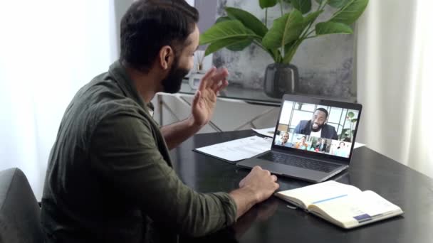 Videollamada. Indio freelancer inteligente o especialista en TI, sentarse en un escritorio en casa o en la oficina, comunicarse a través de videollamadas con colegas de diferentes nacionalidades, discutir temas de trabajo — Vídeo de stock