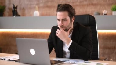 Zeki beyaz adam, ceo şirketi, bilişim uzmanı, bir dizüstü bilgisayarla bir proje üzerinde çalışıyor, bir ara veriyor, bilgisayarını kapatıyor, dinleniyor, yan tarafa bakıyor, gülümsüyor.