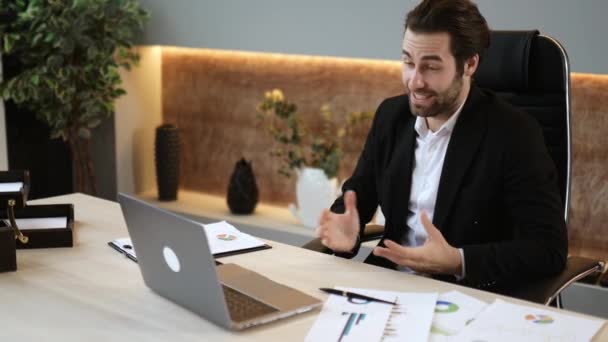 Comunicación remota a través de videoconferencia. Positivo inteligente exitoso gerente caucásico o líder empresarial en traje formal, lleva a cabo una reunión de negocios virtual, habla de forma remota, sonríe — Vídeos de Stock