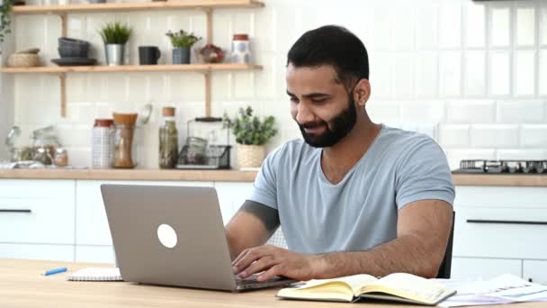 Positivo indiano, freelance, designer, specialista IT, che lavora da remoto a casa, lavora a un progetto in un computer portatile, ha finito un lavoro, ha chiuso il computer portatile, si rilassa, guarda da una parte, sorridente — Video Stock