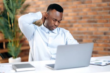 İnternette çalışan Afro-Amerikan iş adamı, satış müdürü, tüccar, ofisinde oturan, boynuna masaj yapan, pazarlıktan çok çalışan, bilgisayar işi yapan, dinlenmeye ihtiyacı olan ya da mola veren