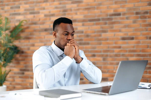 Tense 는 젊은 아프리카 계 미국인 사업가 , CEO 또는 브로커를 집중적으로 컴퓨터 앞에 앉아 일하고, 전략을 분석하고, 작업 계획을 개발하고, — 스톡 사진