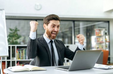 Kafkasyalı başarılı iş adamı ya terfi etti ya da önemli bir projede başarılı oldu. Heyecanlı erkek girişimci büyük kar elde etti ya da iyi bir anlaşma yaptı, başarıyla mutlu oldu.