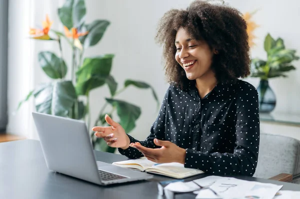Berhasil positif wanita muda afrika wanita freelancer, manajer, CEO, duduk di kantor di laptop, berbicara di video panggilan dengan klien atau karyawan, membahas strategi bisnis, gestur, senyum — Stok Foto