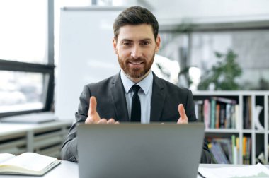 Yoğunlaşmış Kafkasyalı işadamı, bilgi güvenlik mühendisi, sigorta müdürü, modern ofiste oturan, iş arkadaşıyla bilgisayar kullanan, çalışma stratejisini açıklayan, el kol hareketi yapan,