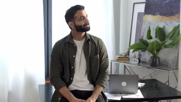 Portret odnoszącego sukcesy pewnego siebie Indianina, menedżera kreatywnego, specjalisty IT, projektanta, ubranego na co dzień, stojącego przy biurku z skrzyżowanymi ramionami, patrzącego w kamerę, uśmiechniętego — Wideo stockowe