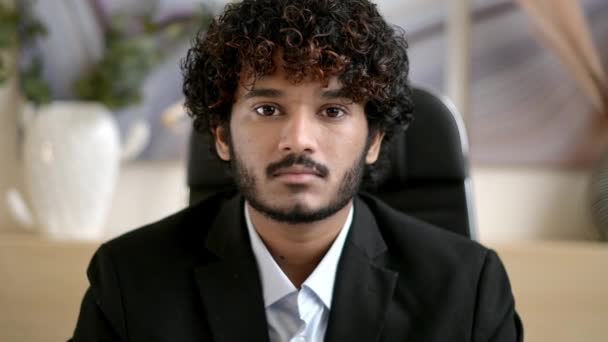 Close-up business portrait. Friendly smiling curly-haired Indian business man, small business owner, company leader or sales manager, in formal suit, successful real estate agent, looking at camera Royalty Free Stock Footage