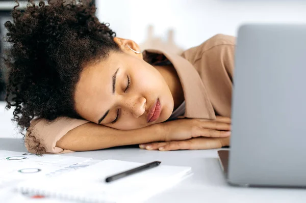 Detailní záběr unavené africké americké dívky, ženy na volné noze nebo studentky, usnula u stolního počítače v blízkosti notebooku, přepracovaná z práce nebo studia na internetu, potřebuje odpočinek a spánek — Stock fotografie