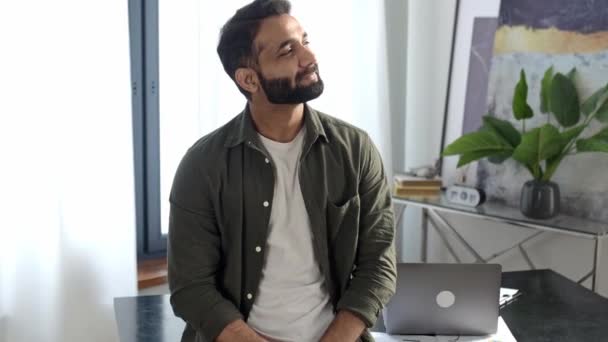 Retrato de un exitoso hombre indio guapo, gerente creativo, especialista en TI, director ejecutivo de la empresa, en ropa casual, de pie cerca del escritorio en la oficina moderna con los brazos cruzados, mira a la cámara, sonrisa amistosa — Vídeos de Stock