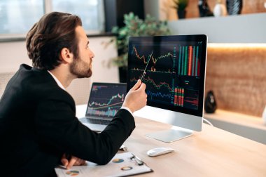 Successful caucasian male trader investor, analysing cryptocurrency financial market, focused looks at a screen, planning a crypto strategy, analyzing risks. Investments, trading on the stock exchange