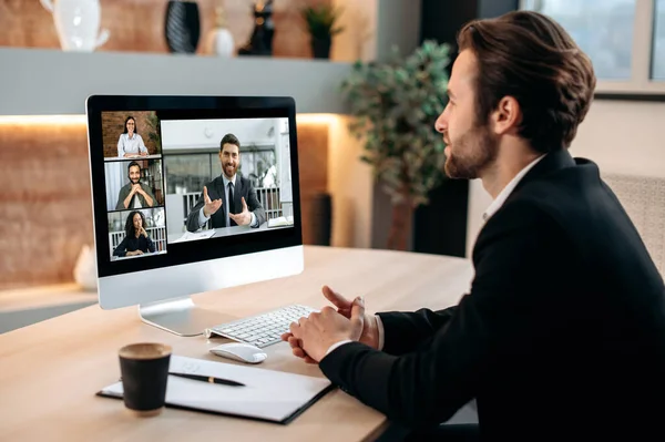 Video konferensi dengan mitra bisnis. Orang Kaukasia bisnis yang sukses duduk di kantor modernnya, berbicara tentang panggilan video dengan rekan-rekan, bekerja di luar rencana bisnis, membahas proyek baru — Stok Foto