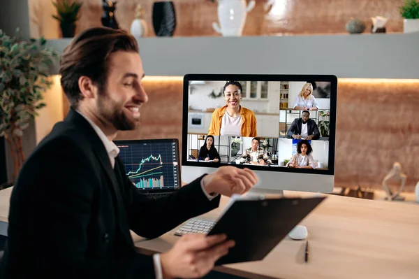 Group brainstorm by video call. Successful caucasian male stock agent, conducts online trading lesson, talking by a video conference with team, working out a crypto strategy, discussing risks — Stock Fotó