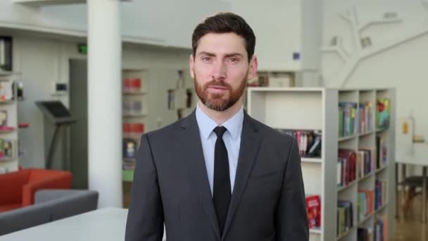 Portrait d'un homme d'affaires caucasien influent, prospère et intelligent, directeur d'entreprise, cadre supérieur, dans un bureau moderne, portant un costume d'affaires élégant, regardant la caméra, souriant amical — Video