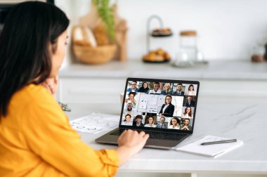 Çevrimiçi öğrenme, profesyonel gelişme. Asyalı bir kız, evde oturup video konferansını dinlerken ekranda beyin fırtınası ya da konferans için bir grup çok ırklı insan toplandı.