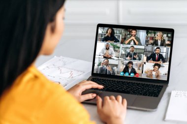 Çevrimiçi video konferansı, grup beyin fırtınası. Bir grup çok ırklı iş adamıyla bilgisayar ekranındaki kızın görüntüsü video görüşmeleri, iş projeleri, iş planları hakkında konuşmalar.
