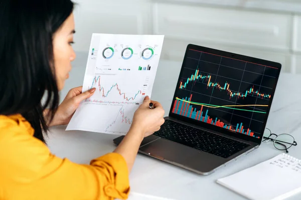 Succesvolle slimme vrouw crypto handelaar, een investeerder, maakt gebruik van laptop, analyseert de grafieken van de handel in de aandelenmarkt van digitale cryptogeld uitwisseling, analyseert, koopt en verkoopt crypto munten — Stockfoto