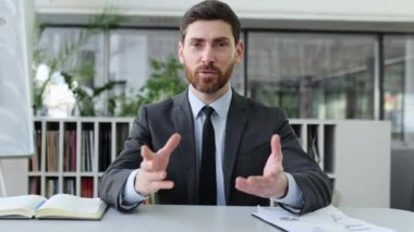 Zeki, başarılı, beyaz iş adamı, üst düzey yönetici, finans danışmanı, şirketin CEO 'su, iş arkadaşlarıyla online konferans yoluyla sohbet ediyor, elleriyle hareket ediyor, dostça gülümsüyor.