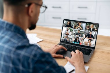 Uzaktan iletişim. Bir grup çok ırklı insanla bir bilgisayar ekranından iş meseleleri ve yeni bir proje hakkında konuşmak ve iletişim kurmak için bir video konferansında bir araya geldi.