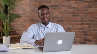 Sevimli arkadaş canlısı siyahi adam, menajer ya da mali danışman, bir video görüşmesi sırasında iş arkadaşlarıyla iletişim kuruyor, sonuçları ve stratejiyi modern bir ofiste tartışıyor, uzaktan görüşmeler, selamlaşma jesti