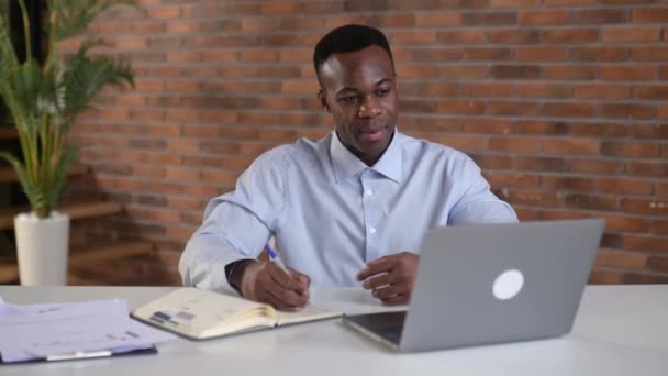 Focused African American Businessman Writing Notes Notebook Online Webinar Improving — Vídeo de Stock