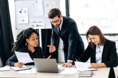 İşbirliği, beyin fırtınası, takım çalışması konsepti. Farklı uluslardan iş adamlarından oluşan bir grup modern bir ofiste yeni bir proje, gelecekteki şirket stratejisi, iş planı üzerinde birlikte çalışıyorlar.