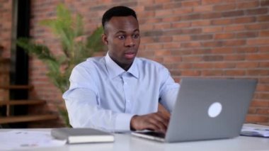 Hüsrana uğramış Afrikalı Amerikalı bir adam, ofis çalışanı, üst düzey bir yönetici, dizüstü bilgisayar kullanıyor, el ele tutuşuyor, kötü haber, başarısızlık projesi, işten yorgun, dinlenmeye ihtiyacı var. Son teslim tarihi kavramı