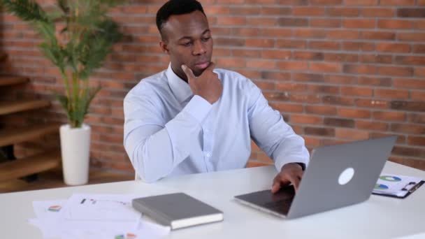 Tenseは若い大人のアフリカ系アメリカ人のビジネスマン Ceoまたはブローカーに焦点を当て ラップトップでオフィスに座って 仕事を分析し 戦略を分析し 作業計画を策定し 会社の利益と損失の半分を維持します — ストック動画