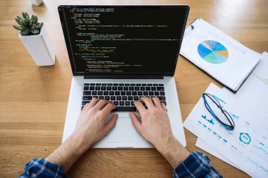 Yazılım konsepti. Dizüstü bilgisayardaki erkek ellerinin üst görünümü, bilişim uzmanı, programcı, dizüstü bilgisayar, daktilo kodu kullanıyor, bir web sitesi geliştirme, uygulama, yazma kodları ve veri kodu üzerinde çalışıyor