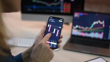 Yakın plan dizüstü bilgisayar ve cep telefonu ekranı. Kripto borsa analizi, kripto para birimi alımı veya satışı için cep telefonu kullanan kadın bir kripto simsarı.