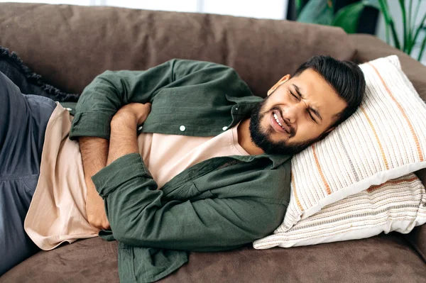 Sad Exhausted Guy Indian Arabian Ethnicity Lies Sofa Living Room — Fotografie, imagine de stoc