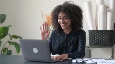 E-öğrenme, uzak iletişim. Pozitif Afro-Amerikan genç kadın, serbest çalışan, öğrenci, ofiste ya da evde dizüstü bilgisayarla oturan, online web sitesi olan, konferans veren, defterine notlar alan, gülümseyen