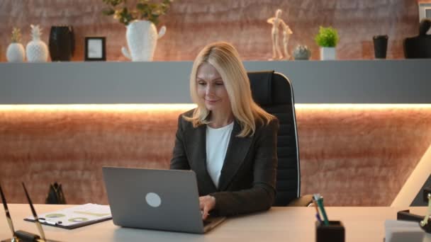 スマート白人成熟したビジネス女性 金融アナリスト トップマネージャー オフィスの彼女の机に座って 財務チャートを勉強し 財務戦略の分析と計画 — ストック動画