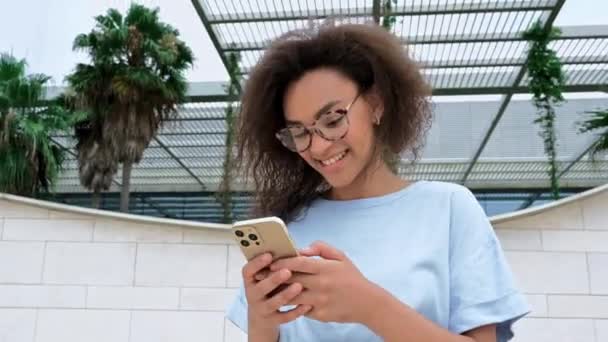 Gadget Drahtlose Technologie Erfolgreiche Afroamerikanerin Mit Brille Blauem Hemd Steht — Stockvideo