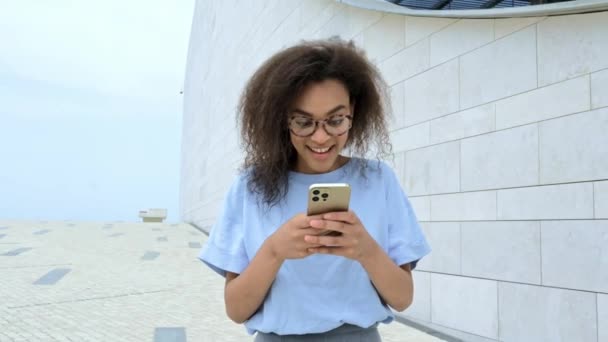 Excited Joyful African American Young Curly Woman Glasses Walking Outdoors — Vídeos de Stock