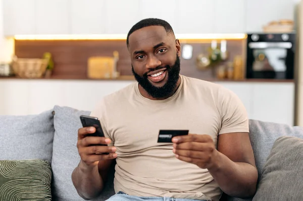 Happy African American Attractive Man Sits Sofa Living Room Holding — Stock Photo, Image