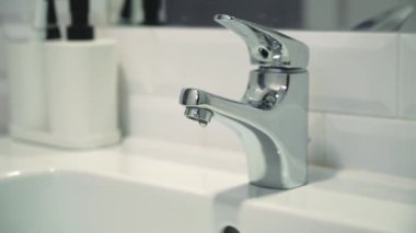 Water faucet, broken faucet. Running water in bathroom in sink. Tap water drops